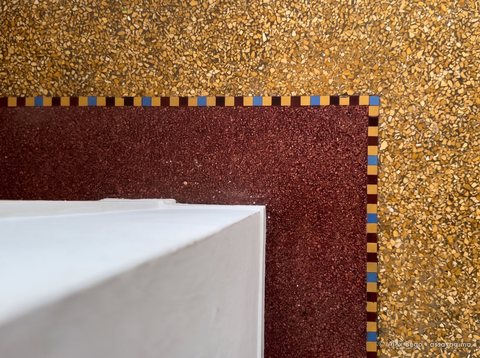 Angle d'un pilastre : bande rouge-brun et champ ocre de granito
