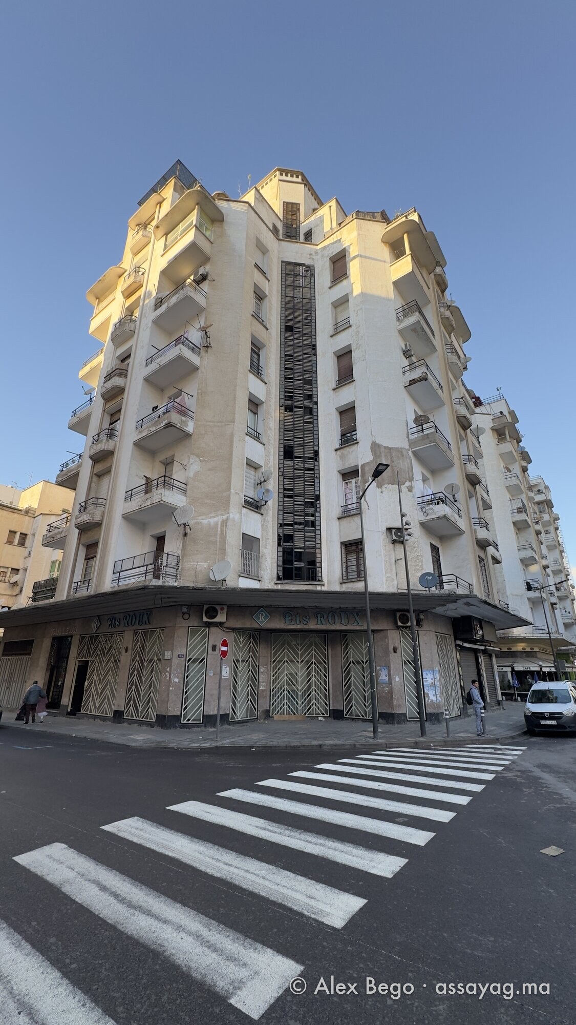 زاوية عمارة الصايغ من ممرّ المشاة: واجهة زجاجية في الوسط وشرفات متراكبة وقمة تحت شمس المساء