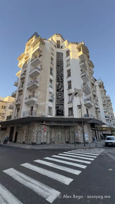 زاوية عمارة الصايغ من ممرّ المشاة: واجهة زجاجية في الوسط وشرفات متراكبة وقمة تحت شمس المساء